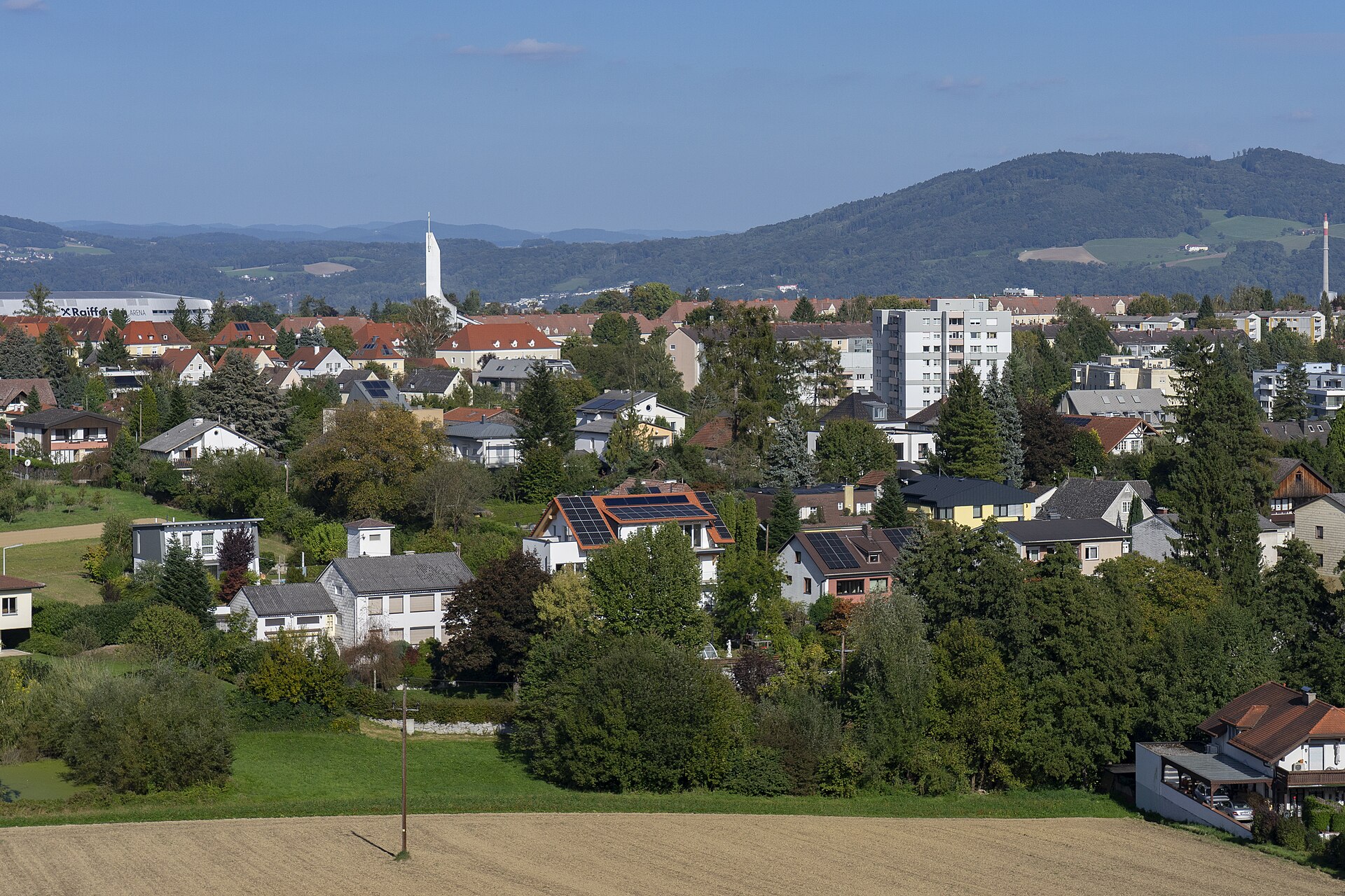 Wohngebiet am Linzer Froschberg mit Kirche St. Konrad und bewaldeten Hügeln